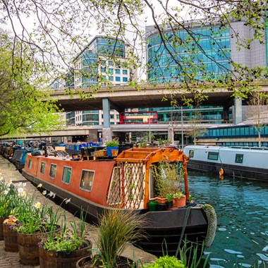 narrowboat moored on the Grand Union canal with flowers outside