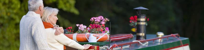 senior couple cruising on their narrow boat 